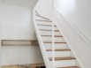 Un escalier blanc et bois pour monter au dernier étage 