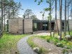 En Suède, une maison en bois se fond dans une forêt de pins