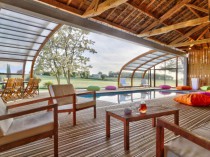 Un abri de piscine en bois ferme un hangar pour ...