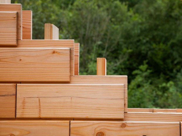 Les briques d'une maison en bois assemblées comme un jeu de Lego