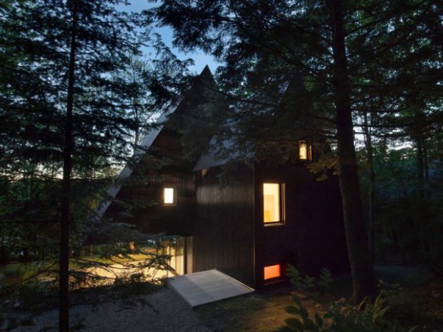Une maison en bois noir dans la forêt canadienne