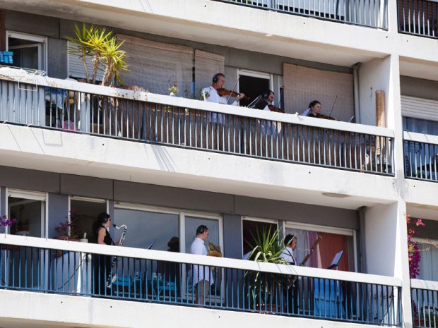 Musiciens jouant sur une façade d'immeuble