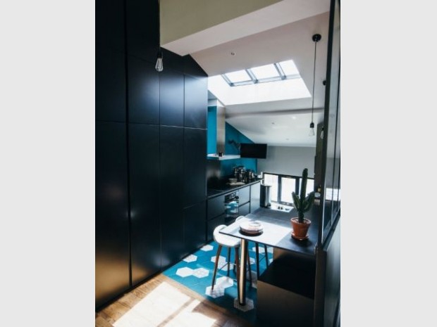 Une cuisine entre carreaux bleu et placards noir mat