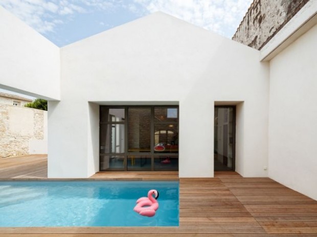 Une maison ouverte sur le patio et sa piscine